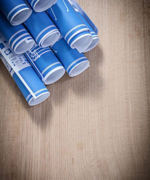 heap-blue-rolled-up-construction-plans-wooden-board_275559-16980